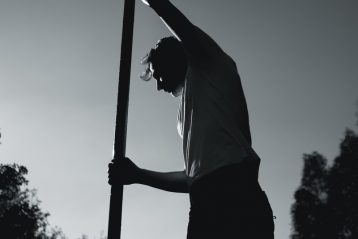 man in white shirt holding pole