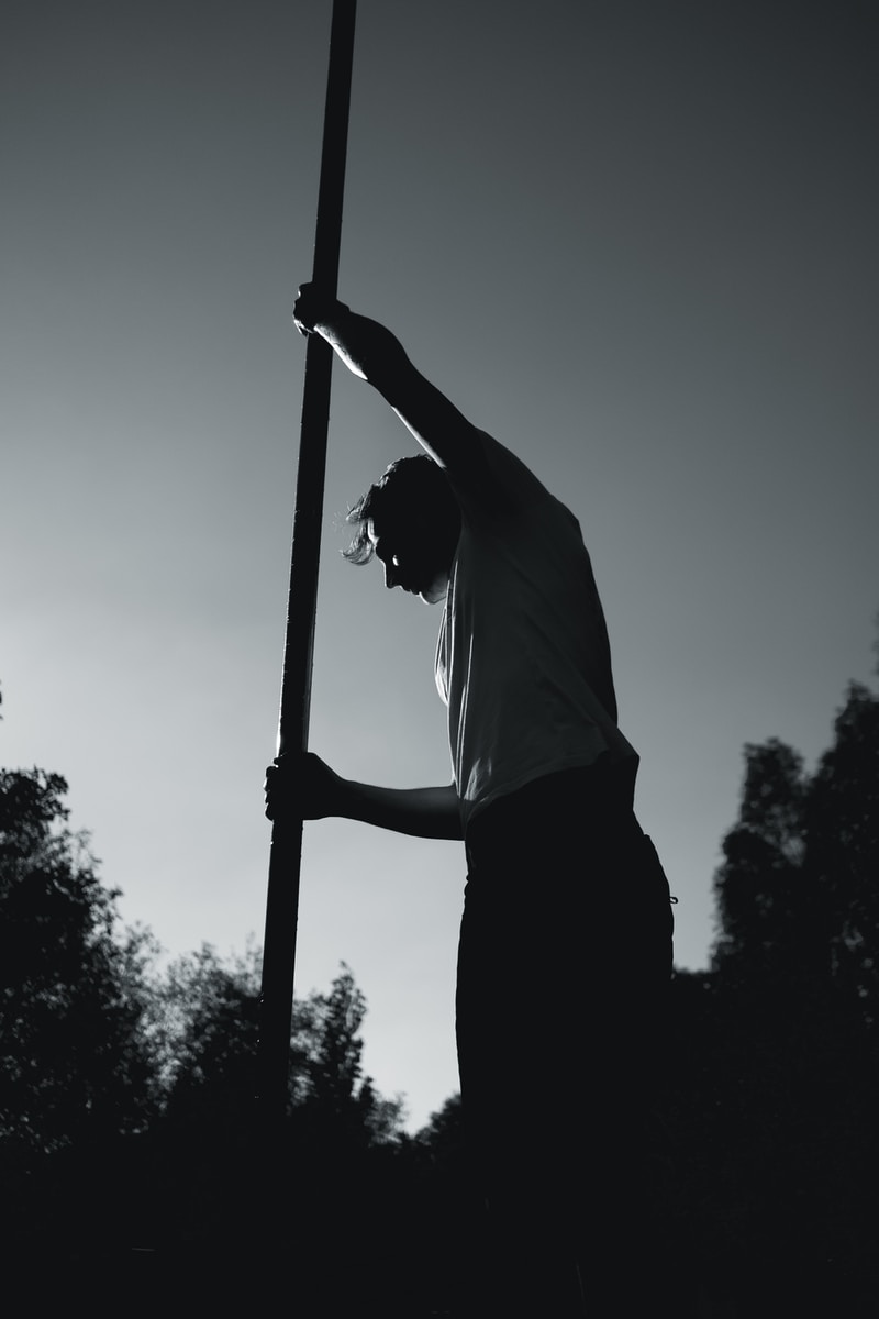 man in white shirt holding pole