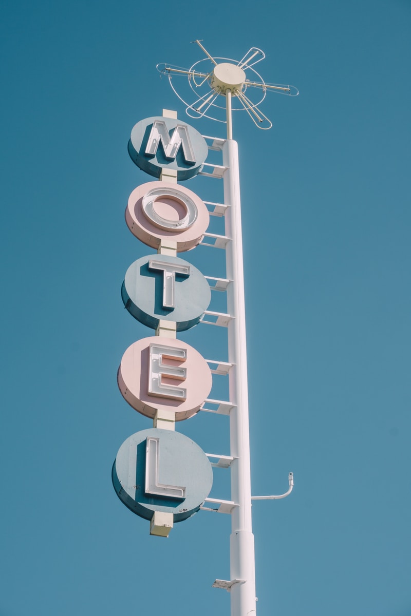 white and teal metal motel signage