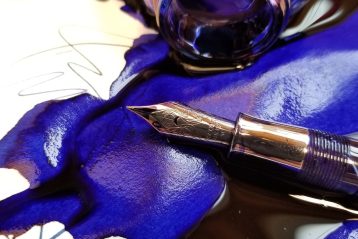 close up photo of spilled blue ink with fountain pen