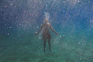 man in black shorts under water