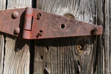 a close up of a metal hinge on a wooden door