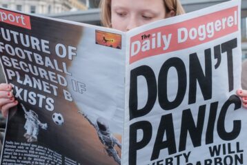 a woman reading a satirical newspaper