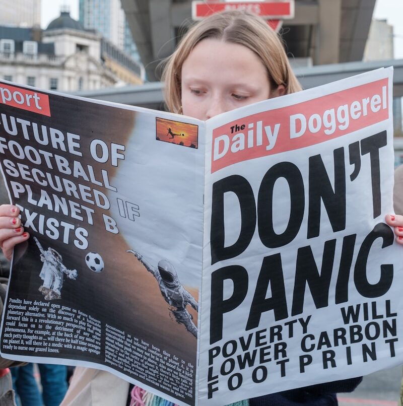 a woman reading a satirical newspaper